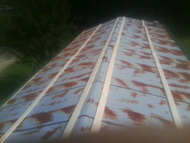 Rusted metal roof panels with new wood purlins before replacement — Storm Damage Roof Repair in Tolovana Park by Roofing Brothers