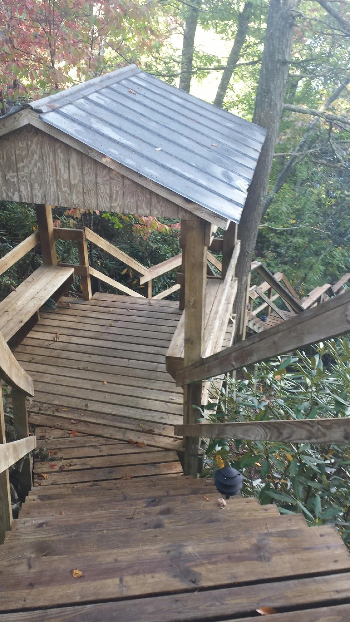 Metal roofed shelter over wooden steps on a wooded walkway — Skylight Repair & Installation work by our crew in Tolovana Park