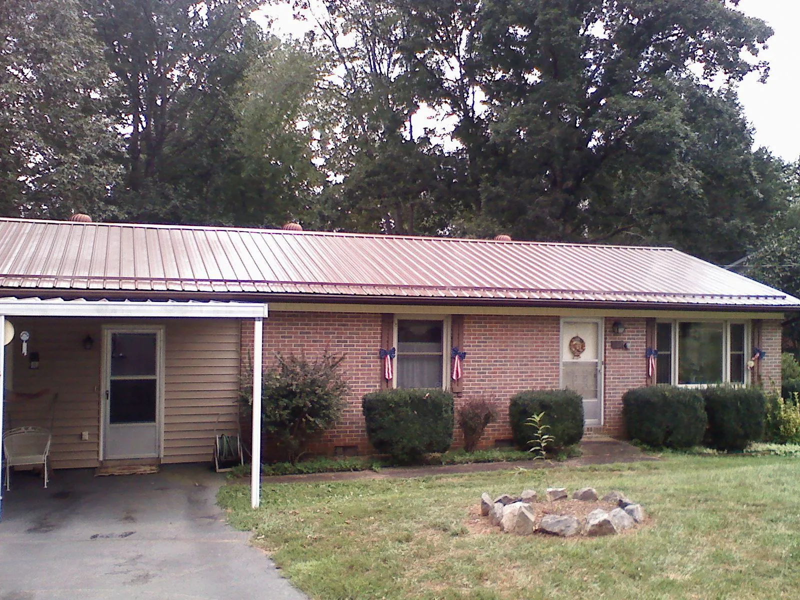 Bronze metal roof and carport on a brick ranch home — Roof Repair work by our crew in Tolovana Park